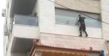 رجل أمن يتسلق عمارة لإنقاذ مسنة علقت بشرفة شقتها.. (صورة)